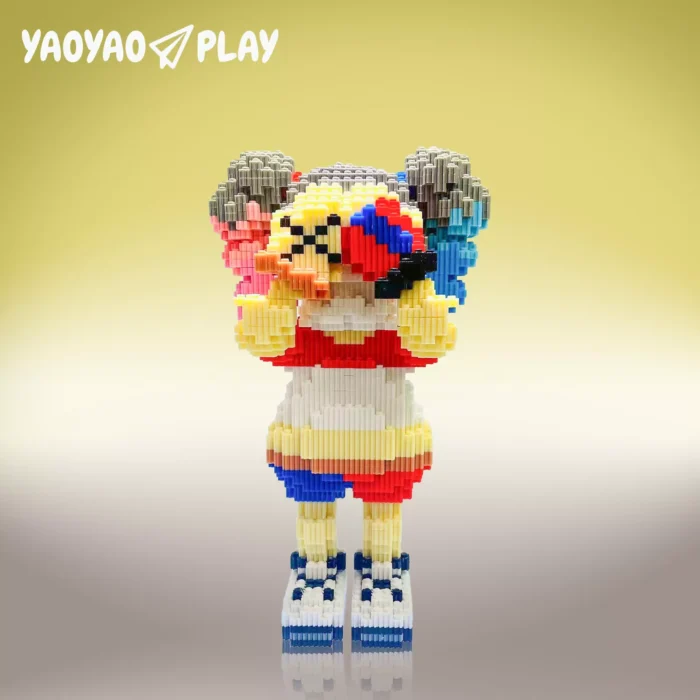 A yellow-and-red ​​Brick Bear toy​​ with raised arms, multicolored hair, and "YAOYAO PLAY" branding on a yellow-white gradient
