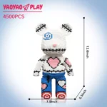 White block-built bear toy with blue swirl eye, pink heart torso, and red sneakers against gradient blue, labeled 'YA0YAO PLAY